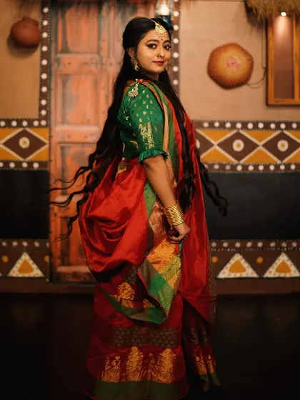 A side profile shot capturing the movement of the hair and the elegance of the saree.