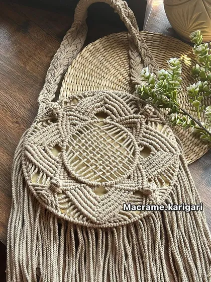 The same round macramé beach bag design in a classic beige. This neutral color is versatile and showcases the detailed knot work and texture of the natural cotton cord.