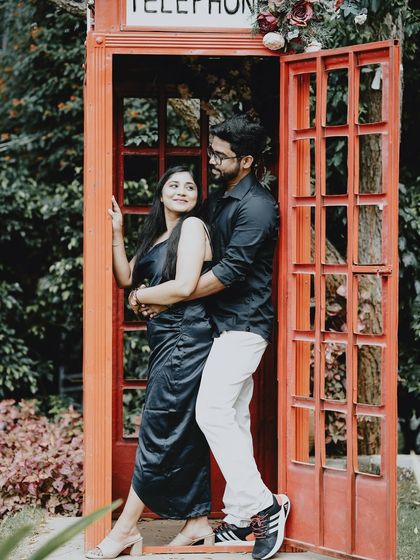 A romantic pose inside a red telephone booth, with the couple embracing, creating a classic and charming pre-wedding photo.