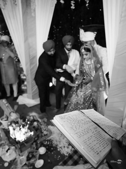 A black and white shot of a wedding ceremony, with the holy book in the foreground. This artistic photo emphasizes the sacredness of the rituals.