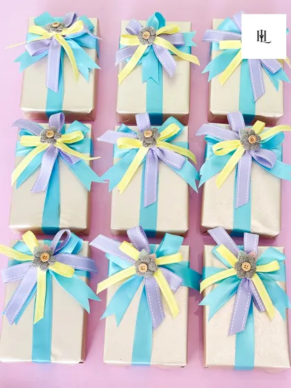 Another example of my bespoke packaging. The combination of pastel blue, yellow, and purple ribbons creates a cheerful and celebratory look for any gift.
