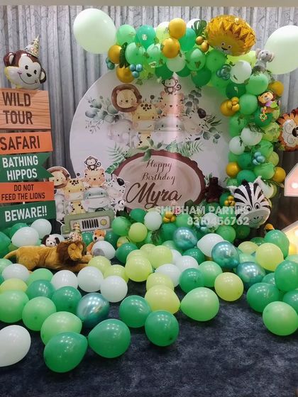 A "Wild Tour" safari-themed birthday decoration with a custom backdrop, animal props, and a large light-up number two.