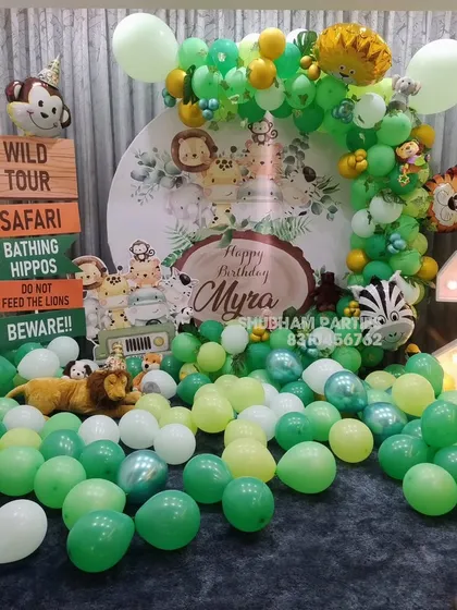 A "Wild Tour" safari-themed birthday decoration with a custom backdrop, animal props, and a large light-up number two.