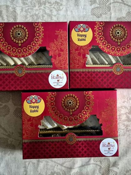 The exterior of my red and gold Rakhi gift boxes. The traditional design and window display make them perfect for the occasion.