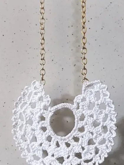 A classic white crochet lace pendant that offers a clean, delicate look. It pairs beautifully with both casual and formal tops.
