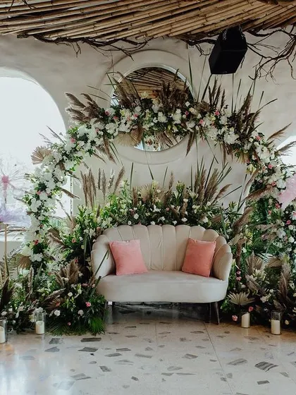 The full view of the bohemian-inspired stage, where natural textures like pampas grass and dried palms are combined with soft florals and candlelight for a romantic, earthy vibe.