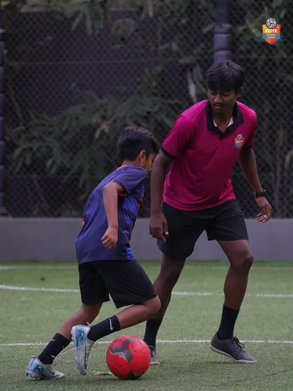 A young player learning defensive positioning from a coach in a personalized session.
