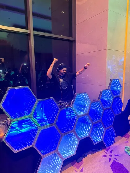 Bringing the energy from behind my custom hexagonal LED DJ booth. This unique console design adds a futuristic and high-end feel to any wedding after-party or corporate event.