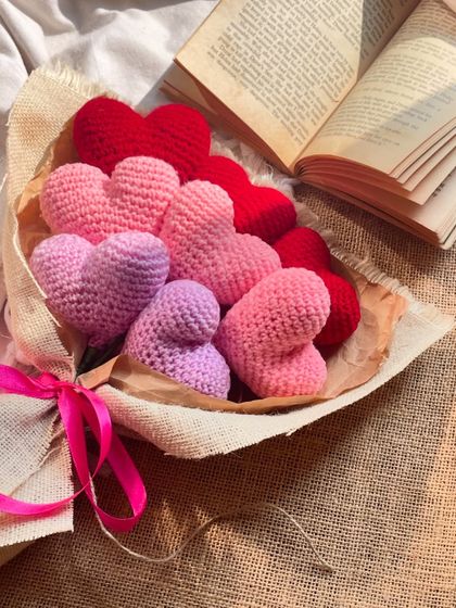 A beautiful flat-lay of the heart bouquet, styled with an open book. The different shades of pink and red create a lovely ombre effect, making it a truly romantic gift.