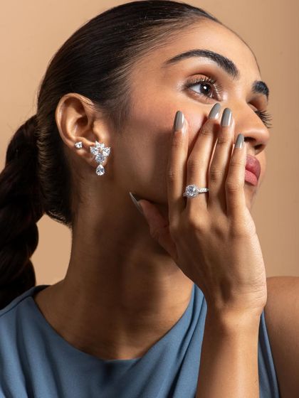 This pose is perfect for highlighting a full set of accessories: ring, ear cuff, and nails. The model's hand gently touching her face feels natural and draws the eye to the sparkling details.