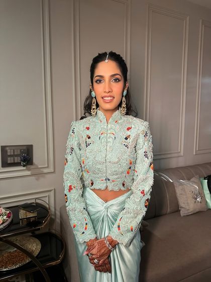 A front-on view of this stunning soft blue look, showcasing the intricate details of the outfit and the flawless, radiant makeup.