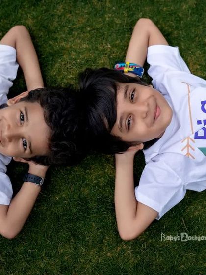 Big brother and little brother, side by side. This sweet overhead shot with their matching shirts is a wonderful way to capture the bond between siblings.