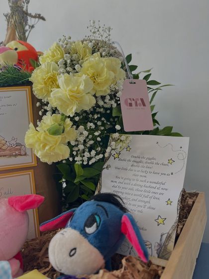 A close-up of the personalized card and Eeyore plushie from the Pooh hamper.