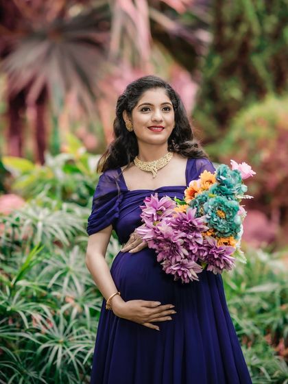 A beautiful solo portrait in a garden, with the mom-to-be holding a bouquet of flowers. The soft, natural light and rich colors create a peaceful and elegant image.