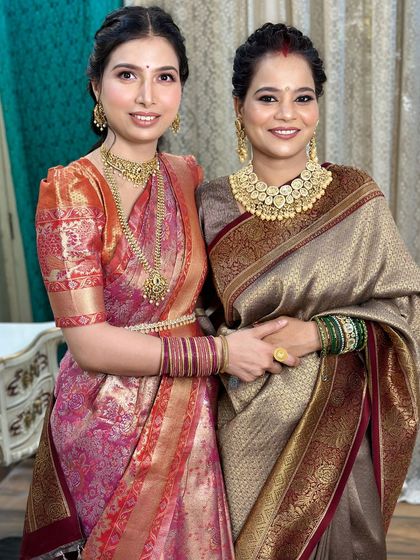 A full portrait of the sisters, showcasing their stunning sarees and jewelry.