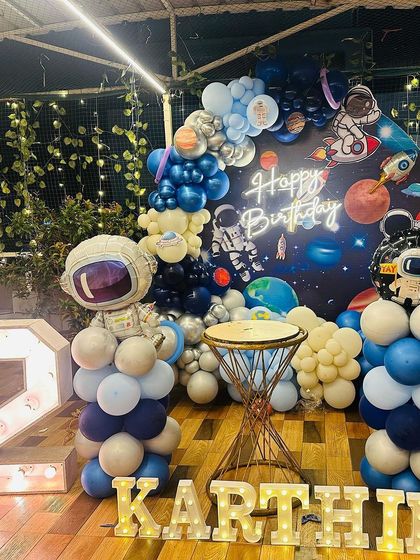 3, 2, 1, blast off! This space-themed setup for Karthik's 2nd birthday was an interstellar adventure. I used a galaxy backdrop, astronaut and rocket cutouts, planet-themed balloons, and light-up letters to create a party that was out of this world.