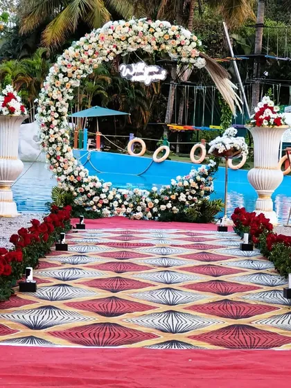 I can transform any venue, including outdoor spaces like this poolside area. I set up a beautiful floral ring arch and a patterned aisle runner, creating a stunning walkway for a modern wedding or reception.