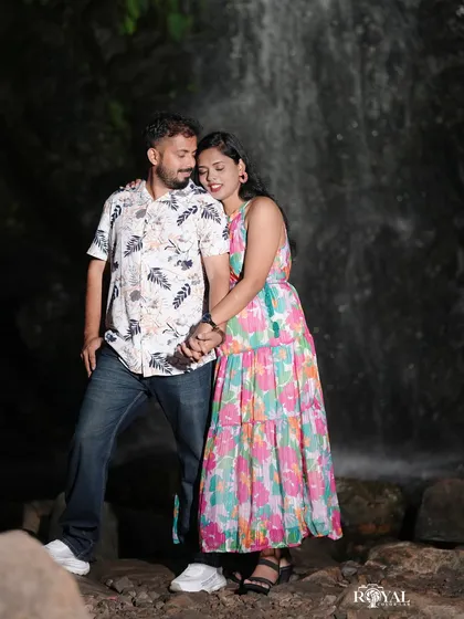 A sweet portrait of a couple holding hands in front of a waterfall, capturing their gentle connection.
