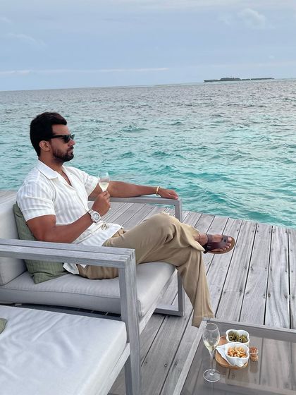 Resort wear at its finest. Our client relaxes by the ocean in a custom striped half-sleeve shirt and comfortable beige trousers.