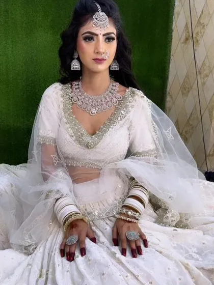 A full-length view of the bride in a white lehenga, showcasing the complete American Diamond jewellery set. This is a popular choice for reception events.