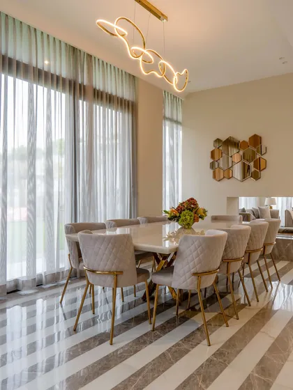 A wide view of the open-plan living and dining space. The design uses furniture groupings and architectural details to define different zones while maintaining a sense of spaciousness and flow.