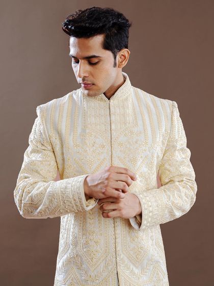 A close-up view of an ivory sherwani, showcasing the texture and precision of the hand embroidery. This image emphasizes the quality and artistry that define our bespoke creations.