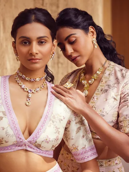A close-up shot from a jewelry-focused campaign, highlighting the intricate details of the pastel necklaces and blouses. The soft, intimate posing was directed to draw attention to the craftsmanship of both the garments and the jewels.