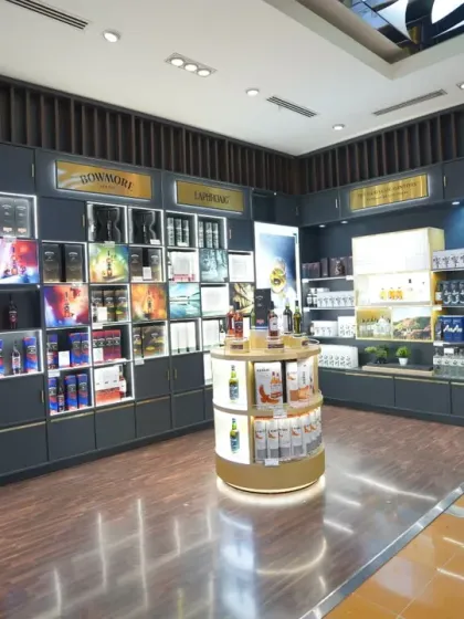 Capturing the mood of a premium liquor store section. The dark, sophisticated interior and illuminated brand displays are expertly lit to convey a sense of luxury and exclusivity in this commercial interior shot.