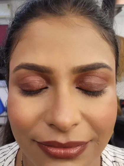A close-up of the eyelids, showcasing the blended bronze and brown eyeshadows used to create this soft smokey effect.