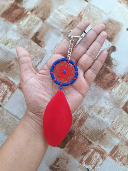 This dreamcatcher charm features a vibrant red and blue design, offering a bold and colorful accessory option.