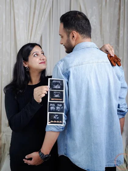 Sharing the journey from the very first scans. This creative shot shows the couple looking back at their baby's ultrasound pictures, a beautiful way to tell the story of their pregnancy.