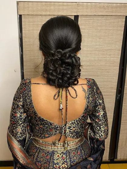 A simple yet elegant messy bun. This versatile updo is perfect for a reception or pre-wedding event, offering a look that is both chic and relaxed.