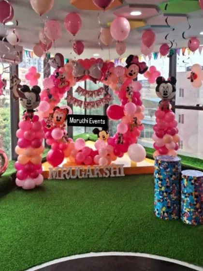 Another angle of the Mickey and Minnie party, showing the balloon decorations hanging from the ceiling and the overall festive setup.
