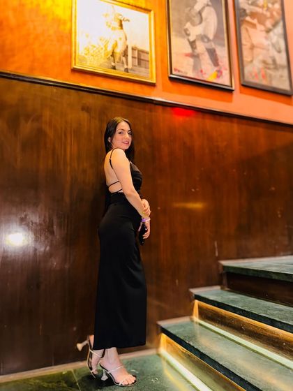 A classic pose on a staircase in a simple, elegant black slip dress. This is a timeless look that never goes out of style.