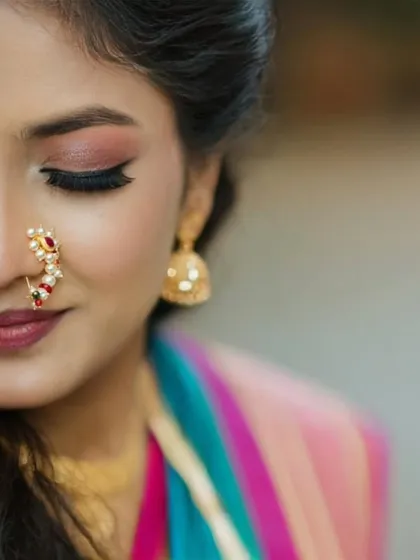 A detailed, artistic close-up of the bride's makeup, focusing on her expressive eyes and the traditional Maharashtrian nath (nose ring).
