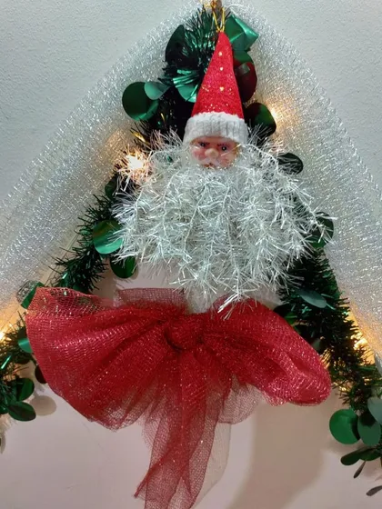 A close-up of a handmade Santa Claus ornament. We believe in adding magical touches to your holiday decor, and small, charming pieces like this bring joy and character to your home during Christmas.