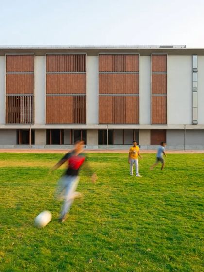 The JSW School of Public Policy at IIM Ahmedabad, viewed from across its recreational lawn. The building is designed to be a part of the active life of the campus, providing a backdrop for both academic and social activities.