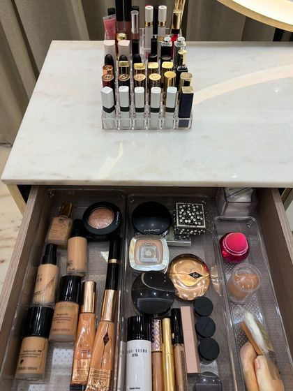 A top-down view of a perfectly organized makeup drawer. Using custom-fit clear trays, we created a specific spot for every product, from foundation bottles to compacts and eyeshadows.