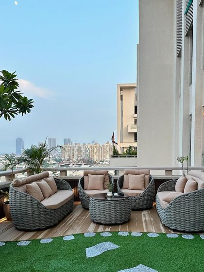 A wide shot of the urban terrace, showcasing the spacious layout with its distinct zones for lounging and greenery. The design provides a clean, open feel while being surrounded by plants.