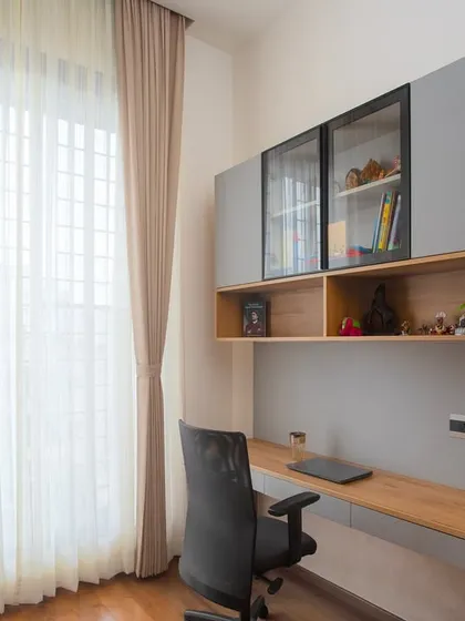 The overhead cabinets with a mix of closed and glass-front doors provide versatile storage, keeping the workspace organized and clutter-free.