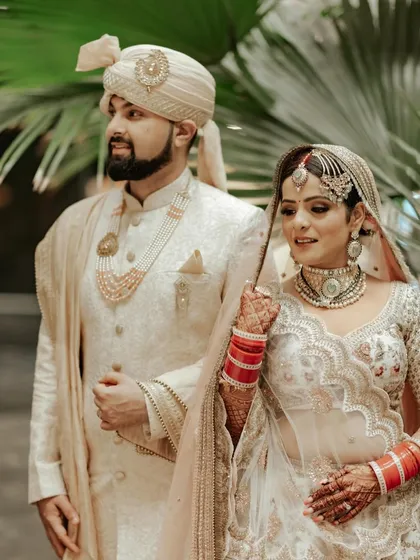A beautiful couple portrait. The bride's pearl choker and matha patti perfectly complement the groom's ivory sherwani.