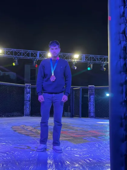 A champion stands alone in the octagon after a hard-fought victory at Elite Combat MMA in Ajmer, a testament to individual dedication and team support.