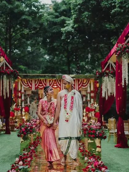 Here, the bride and groom take their first steps as a married couple down a stunning golden mirror aisle. Flanked by floral elephants and lush red arrangements, this moment captures the heart of a royal South Indian wedding, a journey beginning in beauty and tradition.