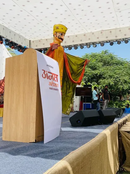 A giant puppet standing tall on the stage at the Anjas Mahotsav in Jodhpur. These large puppets are perfect for outdoor festivals and create a very big impact.