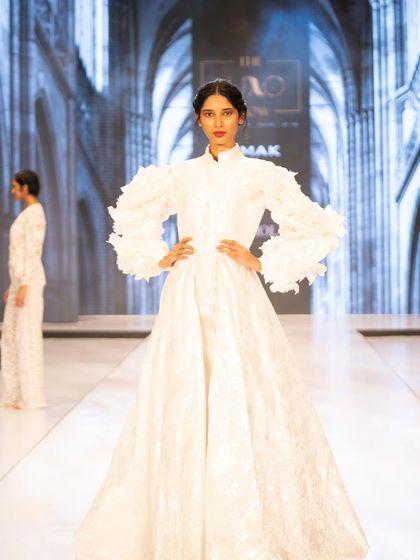 A bold and graphic look for The Luxo Show, featuring a bright red lip that stands out against the all-white structured gown.