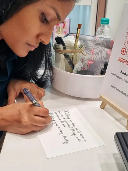 A focused moment, penning a romantic message during a live event. I use pointed pens for this classic, elegant script, perfect for adding a touch of romance to any occasion.