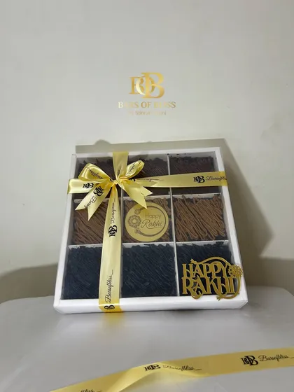 My Rakhi brownie box, beautifully packaged with a golden ribbon and a "Happy Rakhi" tag, making it a complete and elegant gift.