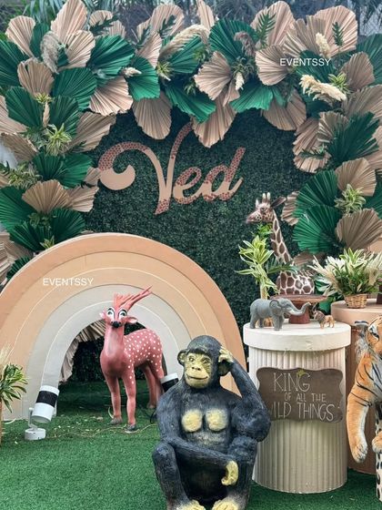 The central backdrop with the birthday boy's name, framed by lush green and neutral-toned paper leaves.