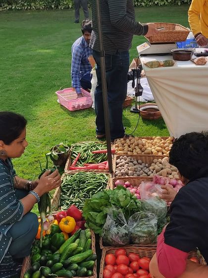 A customer carefully selecting greens from a farmer's stall.