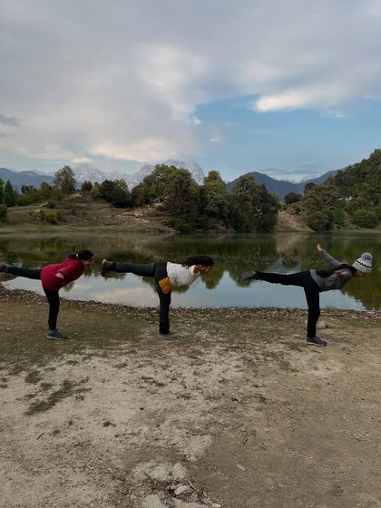 Finding collective balance in Virabhadrasana III (Warrior III) against a stunning mountain backdrop. Group practice helps build focus and stability, as we support and inspire one another.